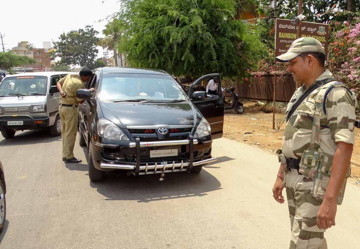 Security personnel intercept vehicles for checking near the Bogadi Ring Road on the outskirts of Mysuru on Thursday.