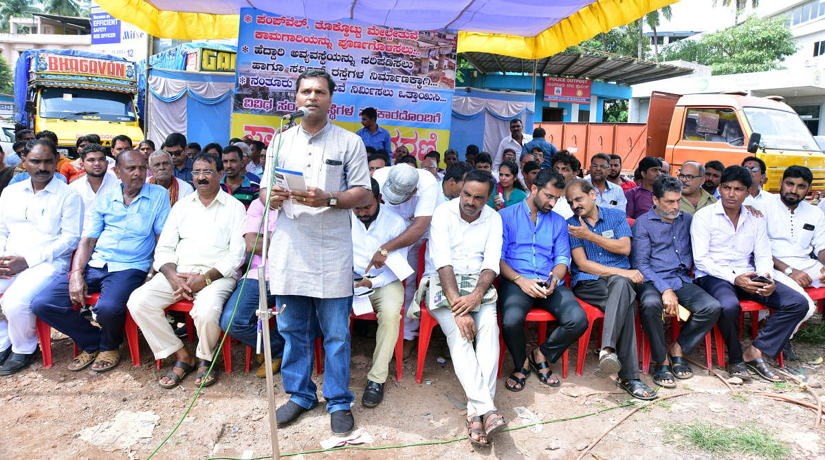 Pumpwell Melsethuve Horata Samithi convener Sunil Kumar Bajal addresses protesters during a protest against the delay in the completion of Pumpwell flyover.