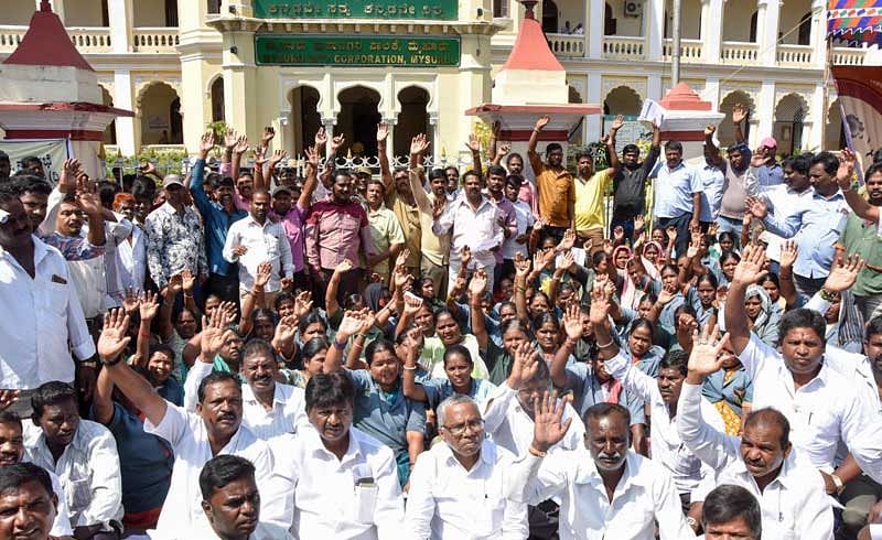 Karnataka Rajya Nagara Palike, Nagarasabhe, Purasabhegala Pourakarmikara Mahasangha members stage protest for various demands in front of Mysuru City Corporation in Mysuru on Wednesday. (DH Photo by Savitha B R)