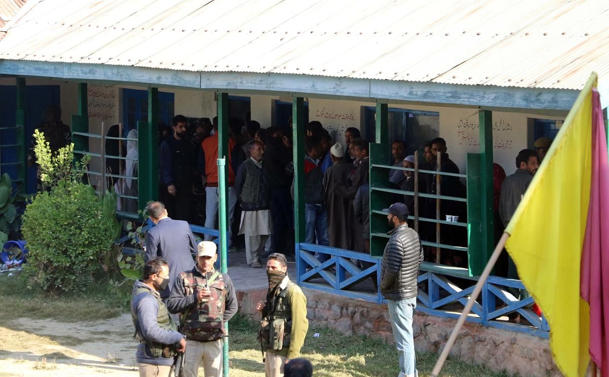 Voters wait in queues outside a polling station in Bemina area of Budgam district to cast their franchise during the first phase of urban local bodies election on Monday. DH photo / Umer Asif