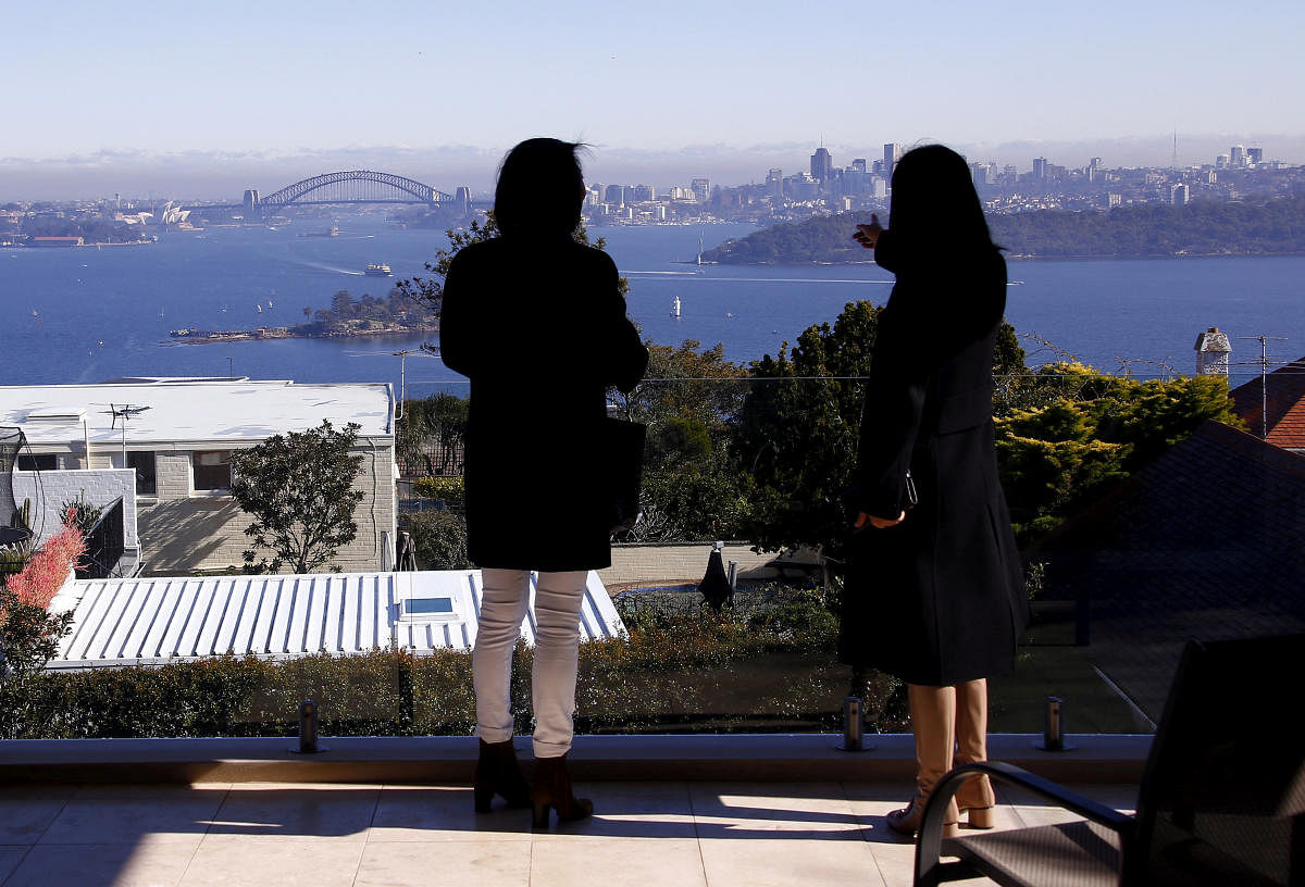  The Sydney Opera House and Harbour Bridge can be seen behind real estate agent and a potential buyer from Shanghai, during an inspection of a property for sale in the Sydney suburb of Vaucluse, Australia, July 11, 2015. Reuters File