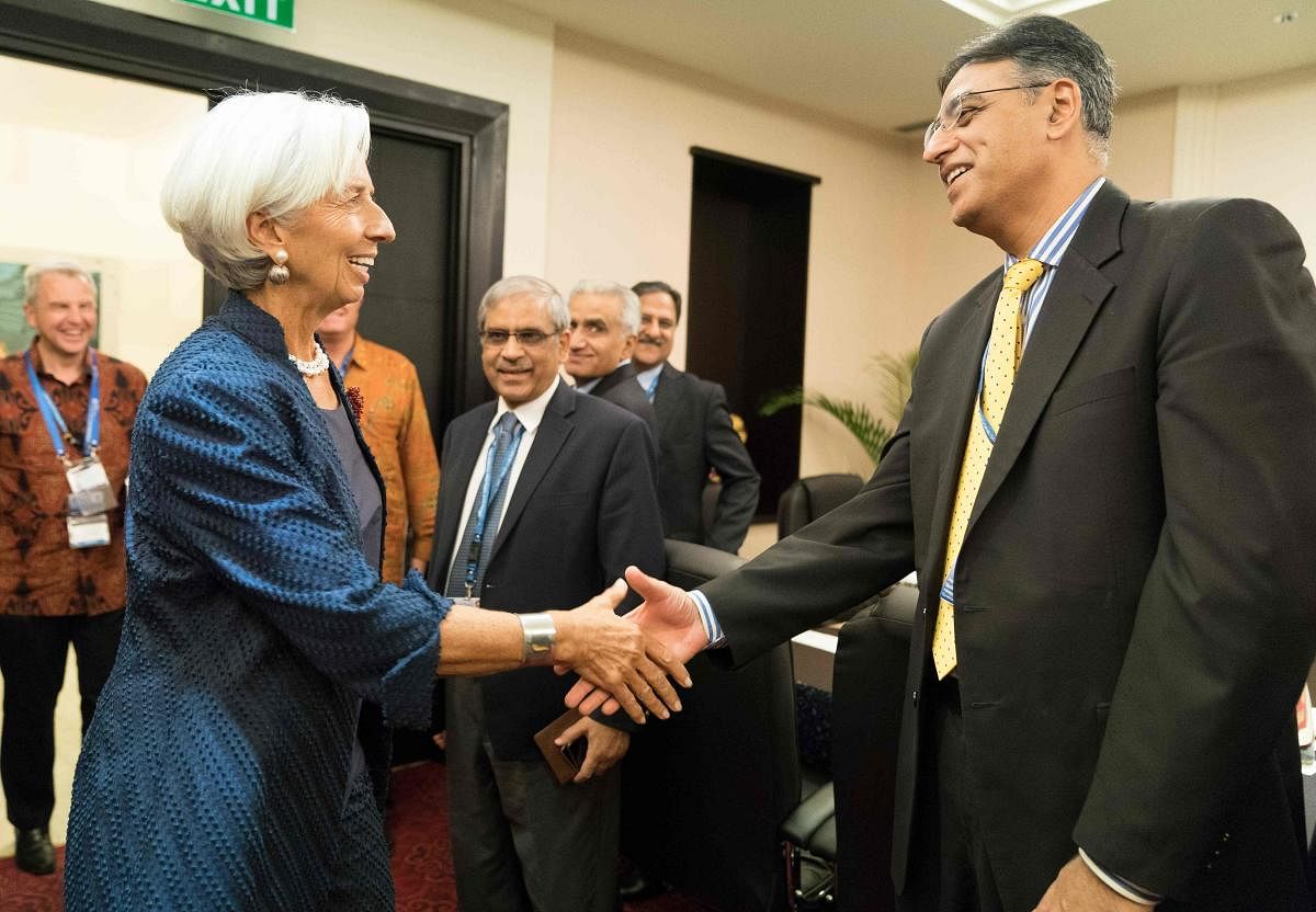 This handout photo taken and released by the International Monetary Fund (IMF) on October 11, 2018 shows IMF Managing Director Christine Lagarde greeting Pakistan Finance Minister Asad Umar at the Bali Convention Centre.