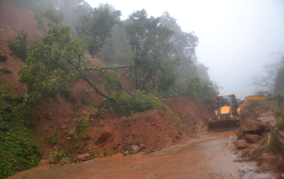 The earth mover pressed to service to clear the soil from NH 275 at Madenadu on Madikeri-Mangaluru road.