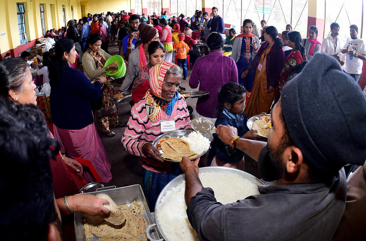 Food is served to flood victims at a relief centre at Suntikoppa in Kodagu district on Tuesday. DH Photo