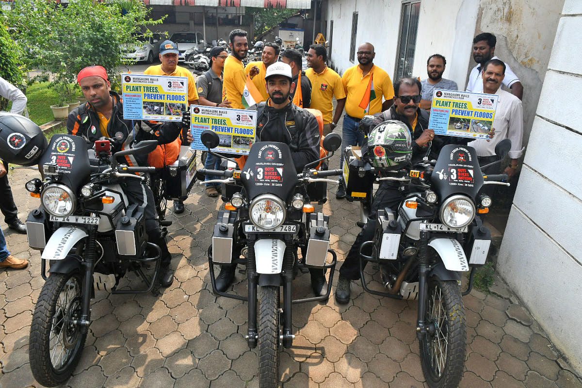 Three bikers hold placards highlighting the importance of afforestation prior to the start of their journey from the office of the Mangaluru Commissioner of Police on Thursday.