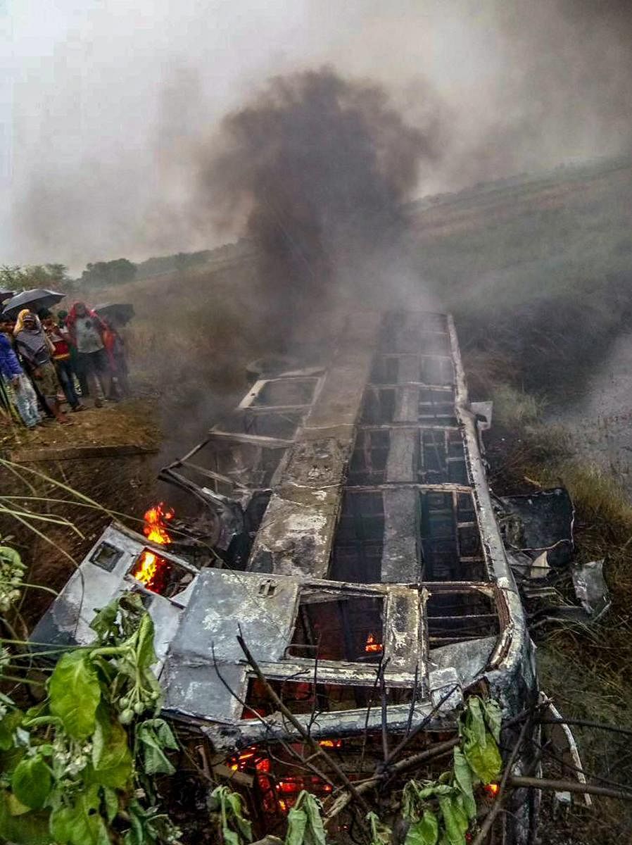 People watch the passenger bus which caught fire in Motihari district of Bihar on Thursday. PTI