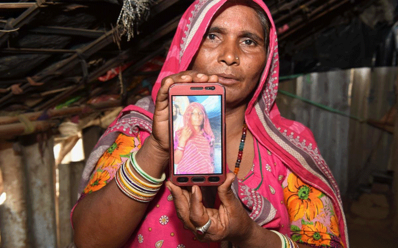 Mohinidevi Nath displays a photo on a mobile phone of her cousin Shantadevi Nath, who was killed by a mob that falsely believed she was intent on abducting children, on the outskirts of Ahmedabad on June 27, 2018. (AFP Photo)