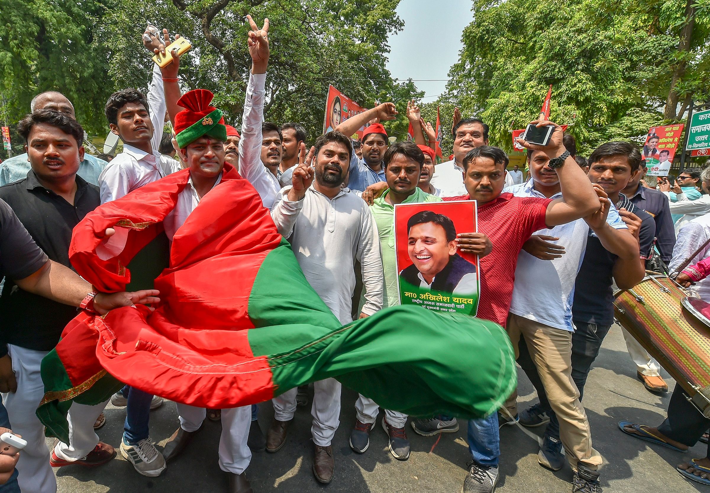 Samajwadi Party workers celebrate their party's success in Uttar Pradesh by-elections, outside their party office in Lucknow, on Thursday. PTI