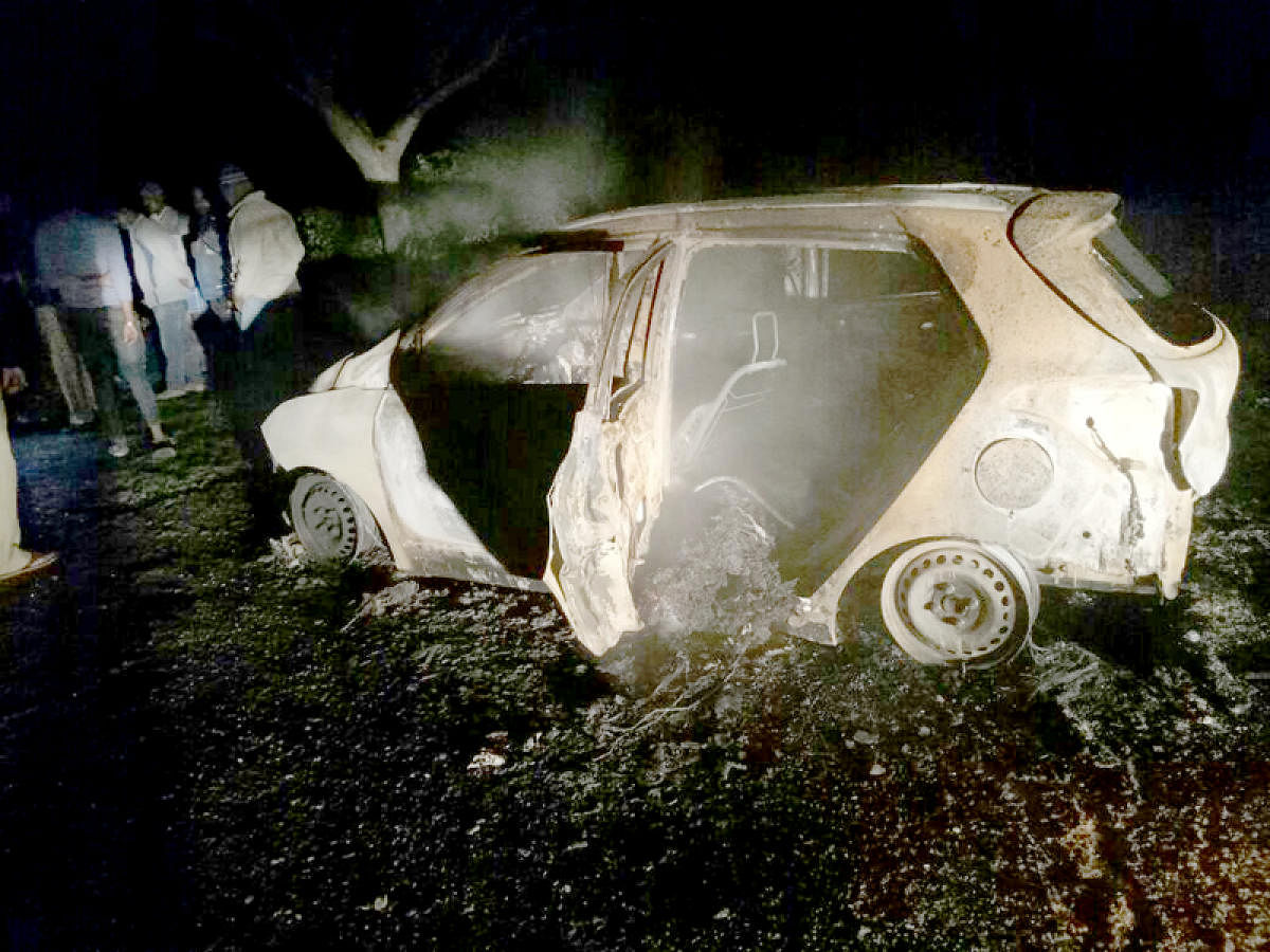 The SUV that caught fire near Pushpagiri Hills in Belur taluk of Hassan district on Friday night. DH PHOTO