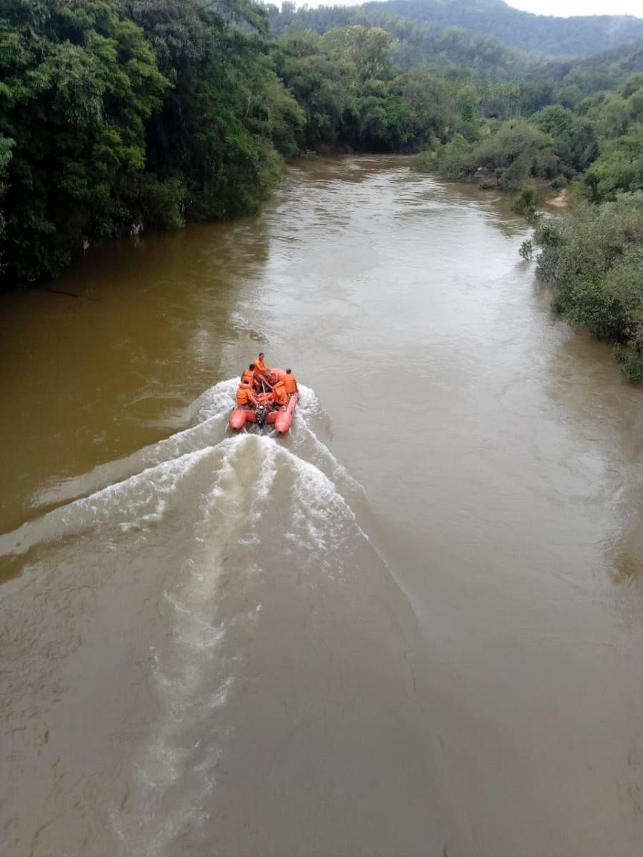 A NDRF search and rescue team sets out on the Tunga river to look for Umesh who was washed away in the river on Friday. DH photo.