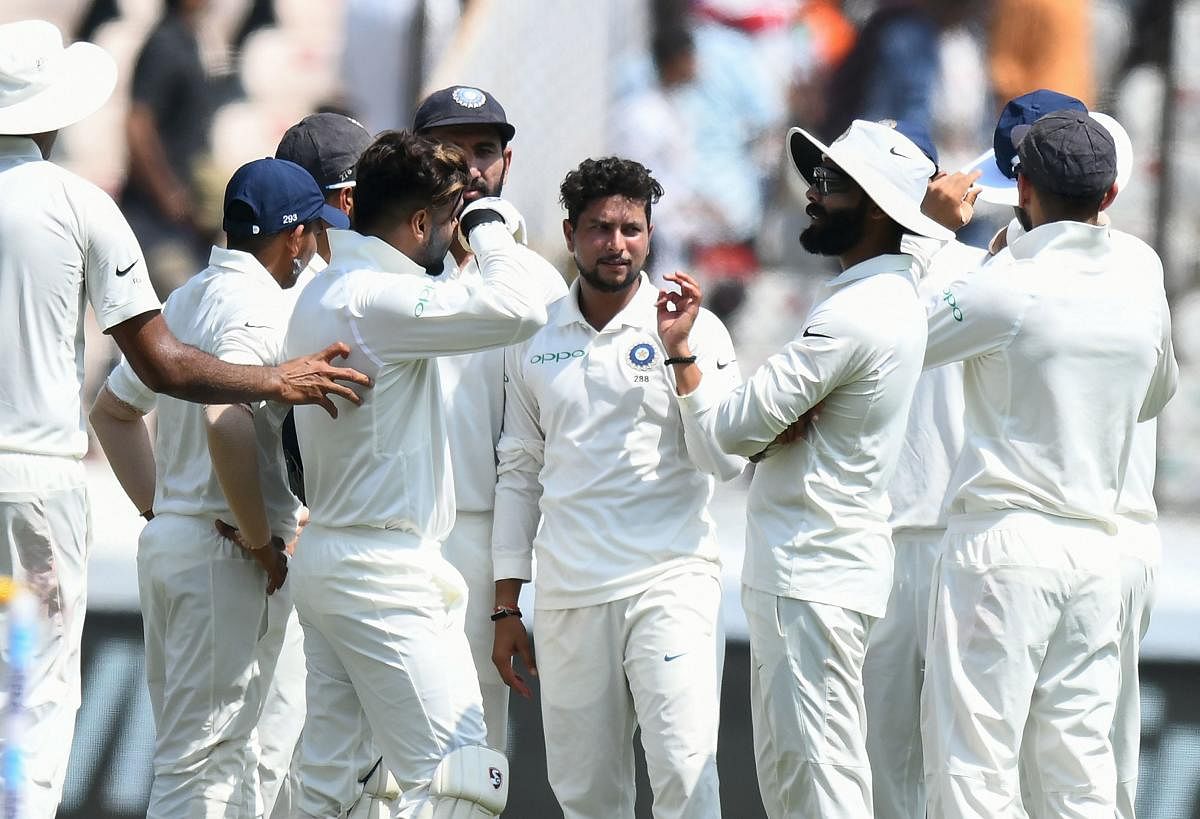 Kuldeep Yadav (C) celebrates with teammates the wicket of West Indies cricketer Kraigg Brathwaite during the first day's play of the second Test cricket match between India and West Indies at the Rajiv Gandhi International Cricket Stadium in Hyderabad on October 12, 2018. (AFP Photo) 
