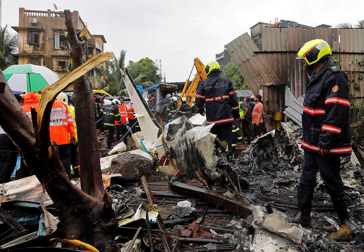 Firefighters inspect the site of a plane crash in Mumbai. Reuters