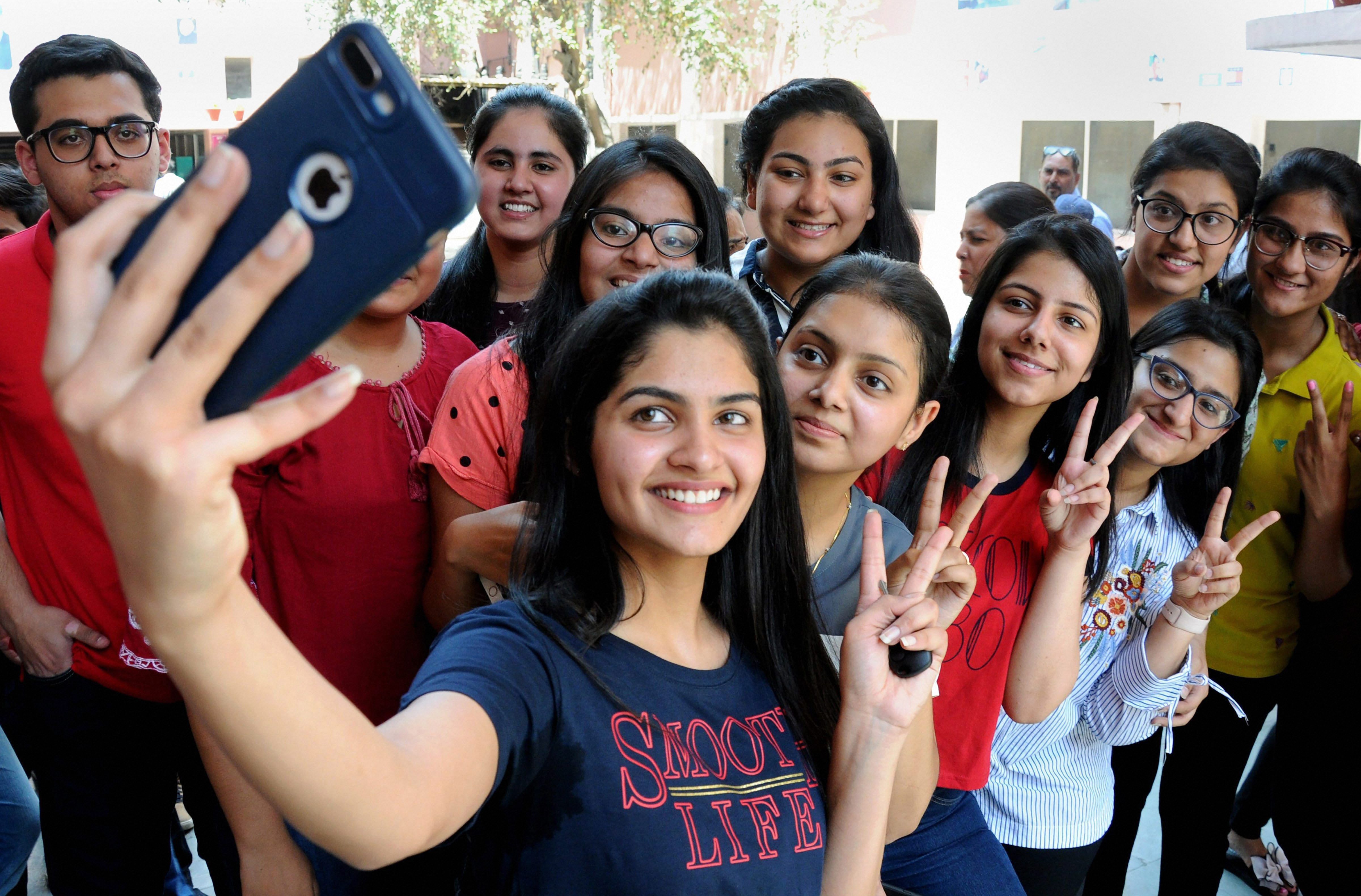 Students take selfies as they celebrate their success after the declaration of CBSE's class XII result, at St Thomas School in New Delhi on Saturday. PTI