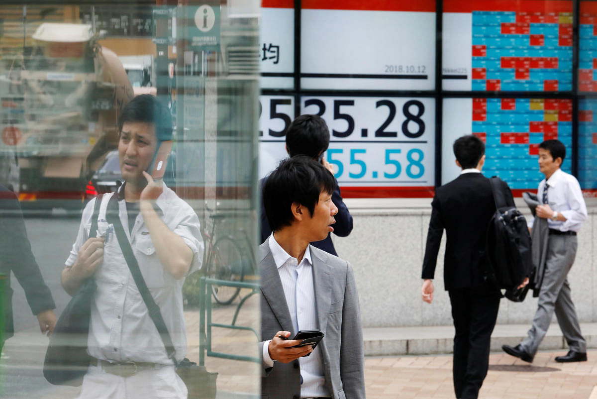 People walk past an electronic board showing Japan's Nikkei average outside a brokerage in Tokyo, Japan. (Reuters file pic)