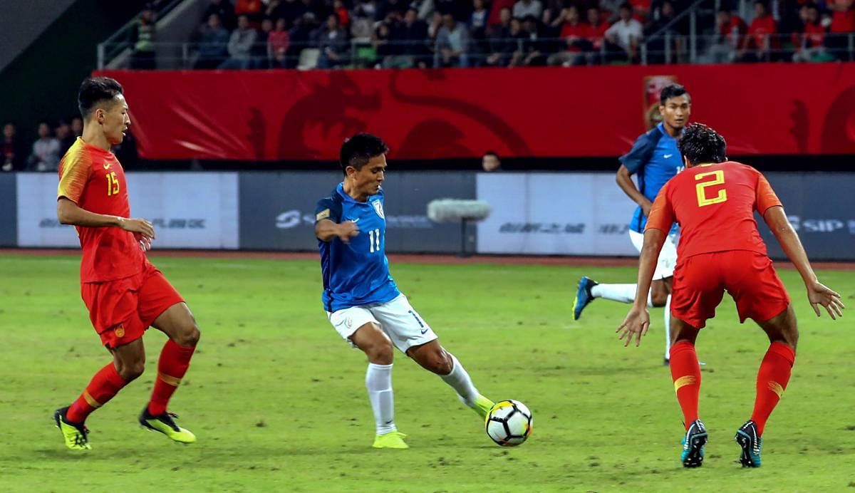 India's Sunil Chettri (C) kicks the ball past China's Liu Yiming (R) during an international friendly football match between China and India in Suzhou in China's eastern Jiangsu province on October 13, 2018. (AFP Photo)