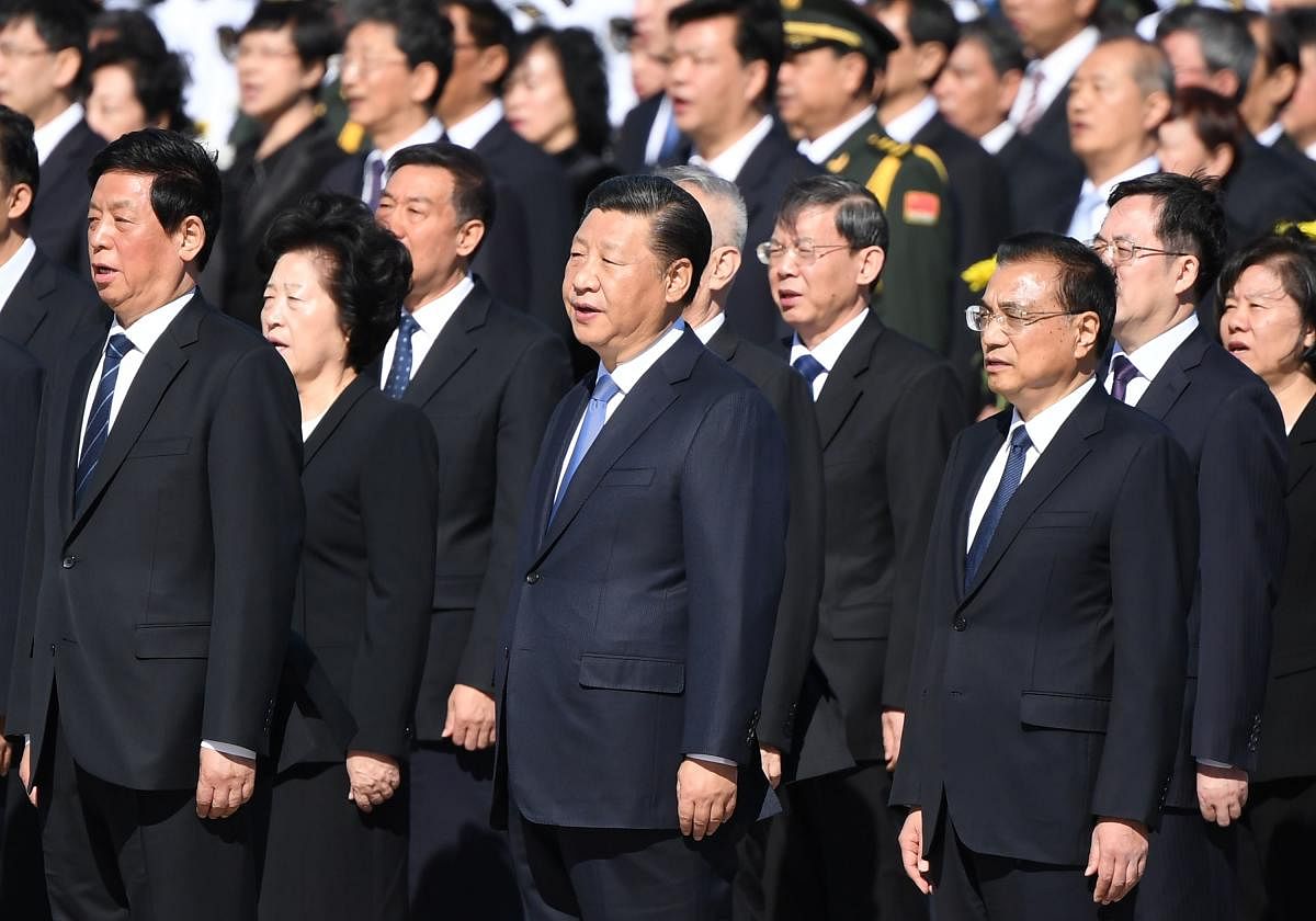 Chinese President Xi Jinping sings the national anthem with National People's Congress leaders during a ceremony in Beijing's Tiananmen Square, on the eve of National Day on September 30, 2018. AFP
