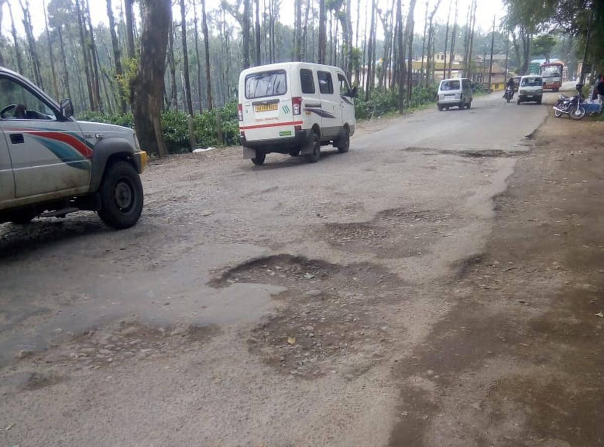 The pothole filled national highway at Handpost in Mudigere.