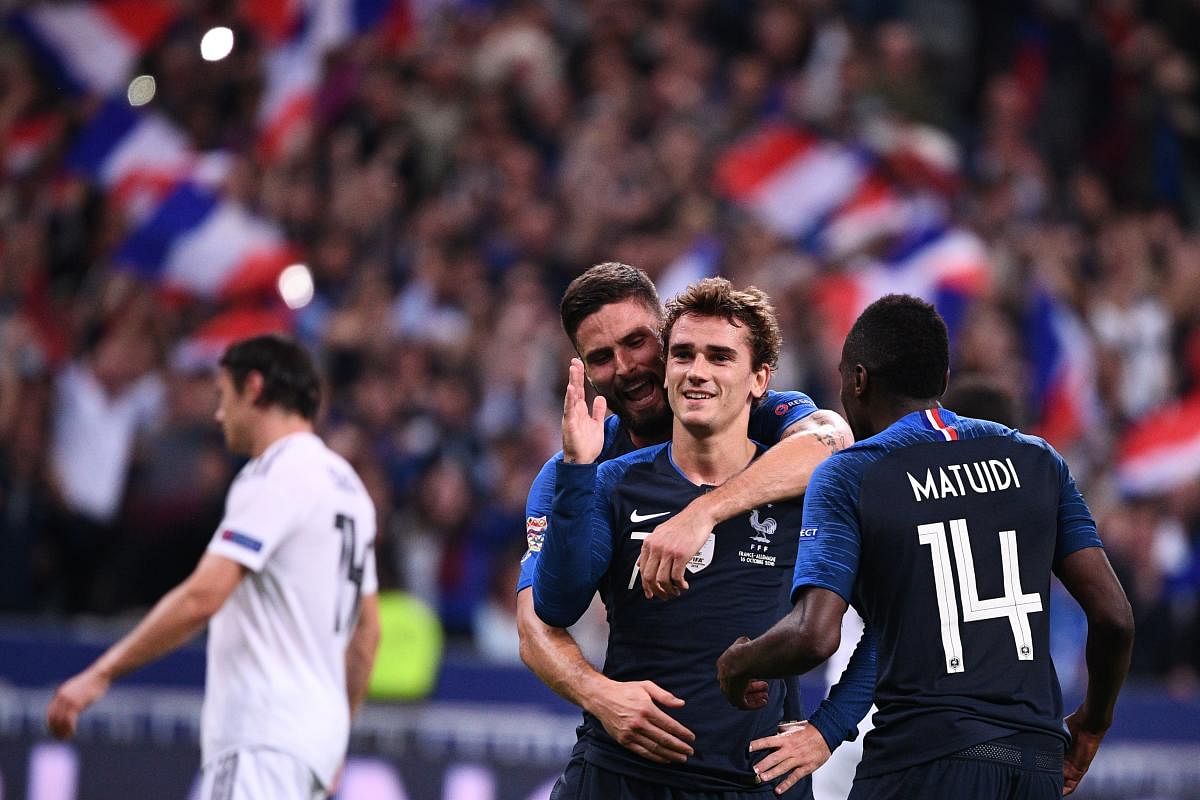 DELIGHTED: France's Antoine Griezmann (centre) is congratulated by Olivier Giroud (behind) and Blaise Matuidi after he scored the team's second goal. AFP 