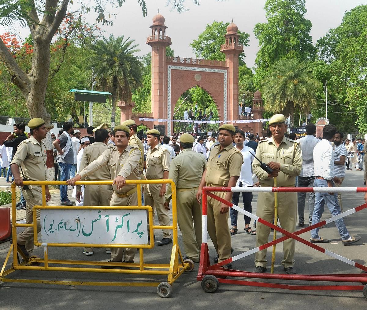 Aligarh: Security personnel stand guard as Aligarh Muslim University students stage a protest over Jinnah portrait issue outside the university gate in Aligarh on Friday. PTI Photo (PTI5_4_2018_000102b)