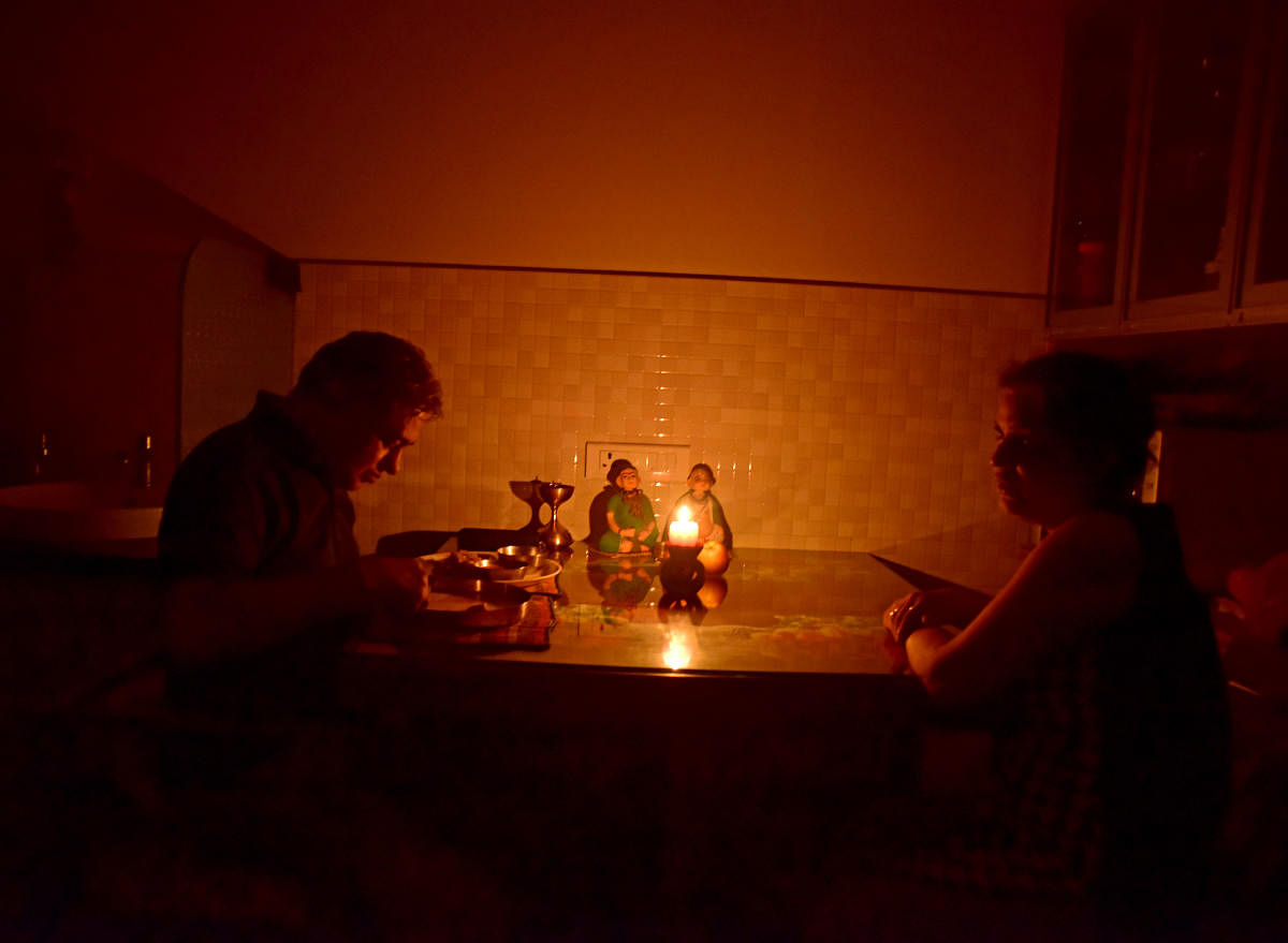 With power connection to their flat disconnected Ramdas Shantaram has dinner by the candlelight, while his wife Veena Shantaram fasting due to Navarathri celebrations watches helplessly. (DH photo/ Govind Raj Javali)
