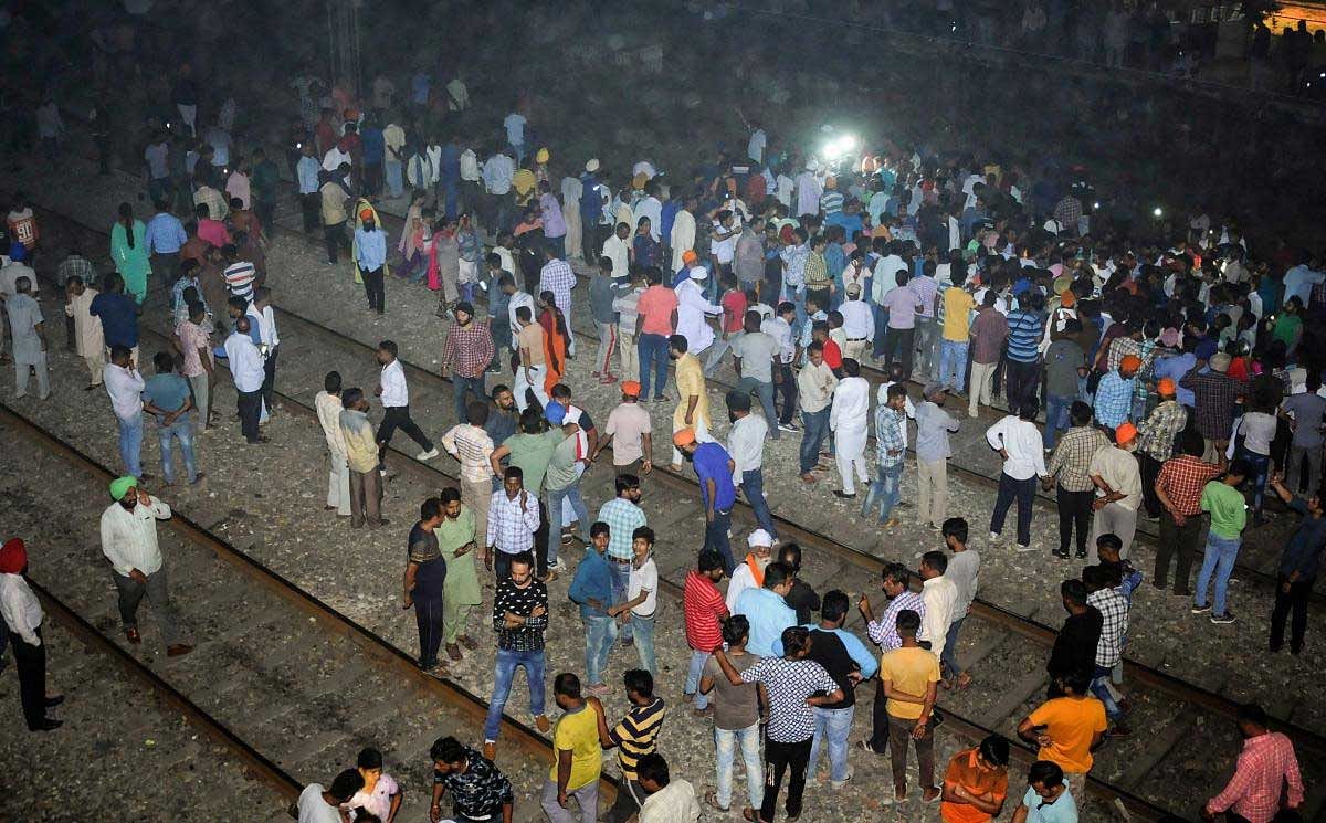 People gather near the site of a train accident at Joda Phatak in Amritsar on Friday. Officials said at least 60 bodies have been found and many more injured have been admitted to a government hospital after the accident near the site of Dussehra festivities. PTI Photo
