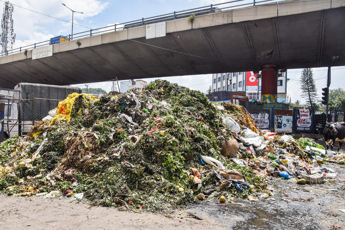 Remains of plantain shoots and mango leaves, unsold flowers and other materials largely used only during festivity dumped after Ayudha Pooja festival at KR Market in Kalasipalya on Friday. DH PHOTOS/S K Dinesh