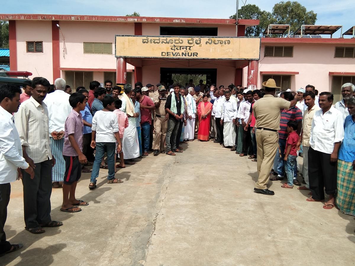 Villagers stage a protest outside Devanur Railway Station on Saturday.