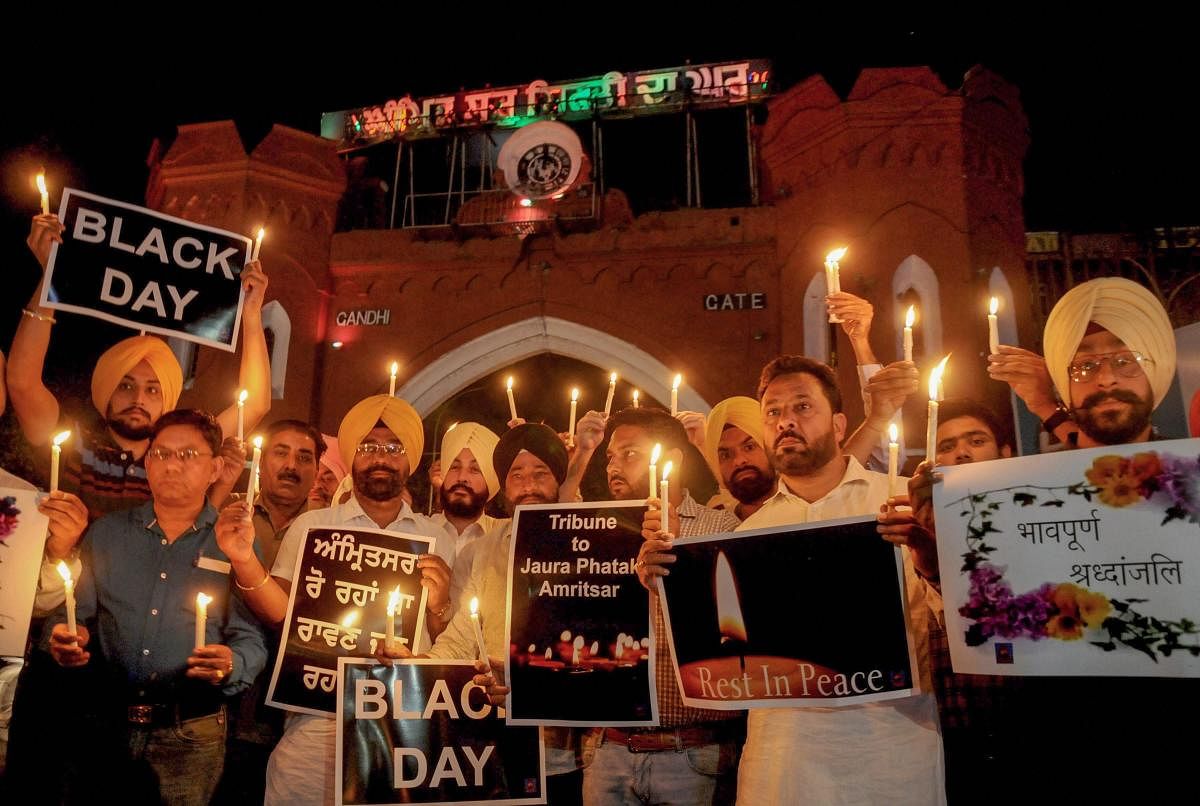 Members of National Human Rights and crime control organisation participate in a candlelight vigil to pay tribute to victims of Amritsar train accident, in Amritsar, Saturday. PTI