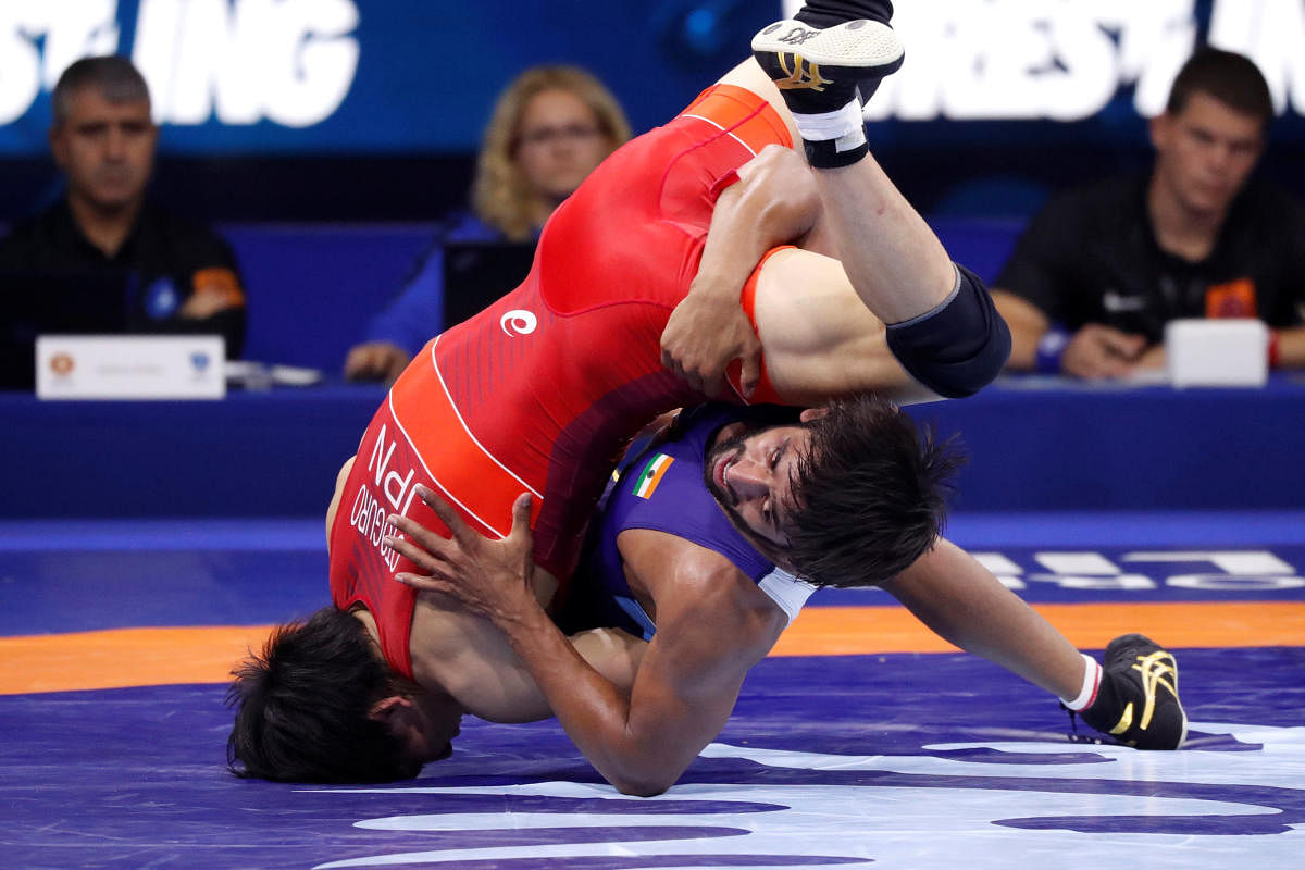 Japan's Takuto Otoguro (red) in action against India's Bajrang Punia on Monday. REUTERS