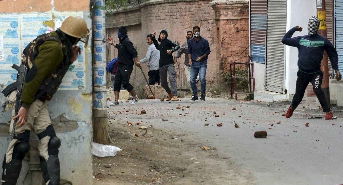 People protesting against the fourth phase of municipal elections, throw stones at security personnel during a clash, near a polling station in Srinagar, on Oct 16, 2018. PTI