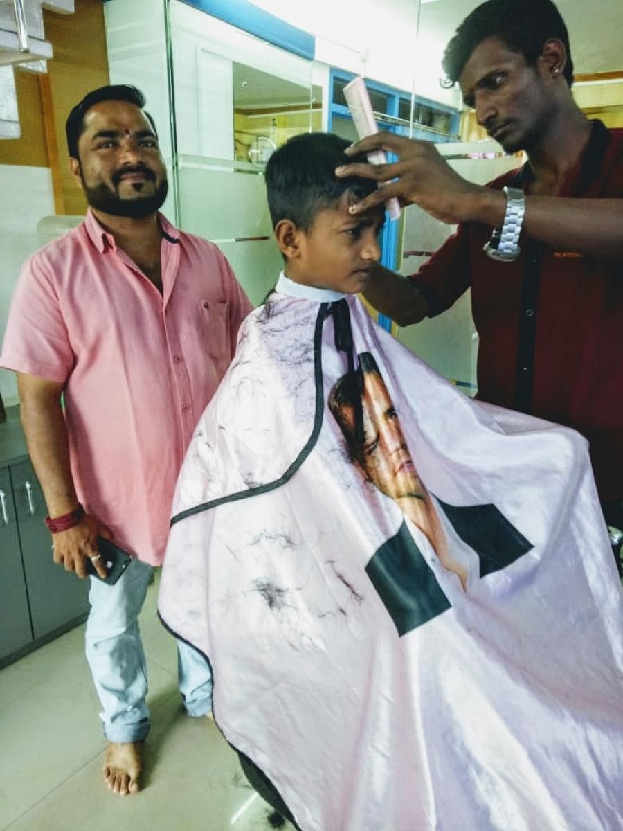 Sanjay Mahale oversees the`free' hair cut given to a student from DK ZP higher primary school at his Kudla Mens professional saloon in Bikarnakatte.