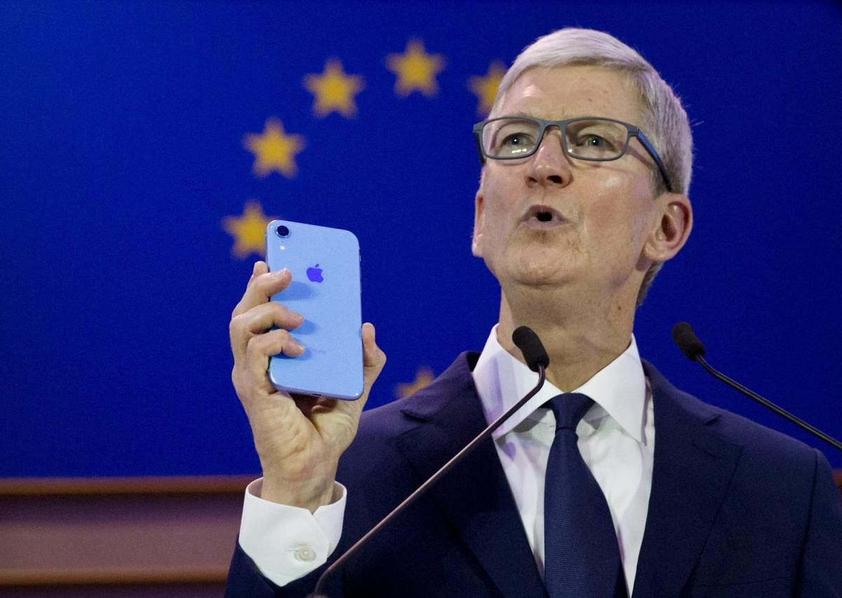 Apple CEO Tim Cook holds up an iPhone as he speaks during a data privacy conference at the European Parliament in Brussels on October 24, 2018. AP/PTI
