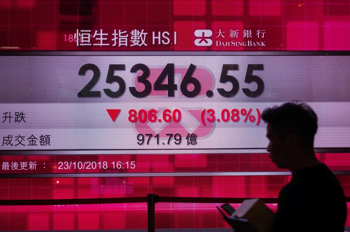 A man walks past a stocks display board that shows a drop in the Hang Seng Index of 3.08 percent, or 806.60 points, closing at 25,346.55 in Hong Kong. AFP file photo.