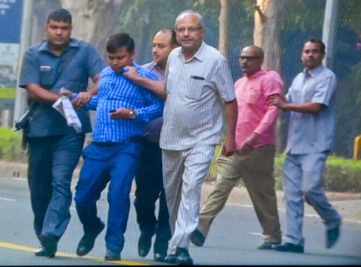 Security personnel detain two of the four people who were seen outside the residence of CBI director Alok Verma for questioning, on Thursday morning, in New Delhi, Thursday, Oct 25, 2018. (Video Grab/PTI Photo)