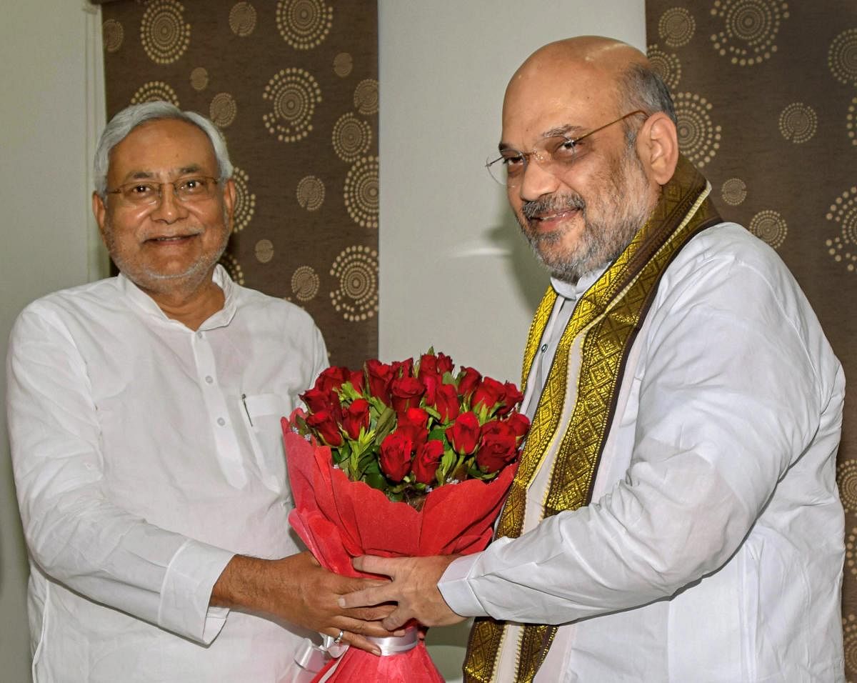 Bihar Chief Minister Nitish Kumar and Bharatiya Janata Party (BJP) President Amit Shah exchange greetings at the state guest house, in Patna on Thursday. (PTI Photo)