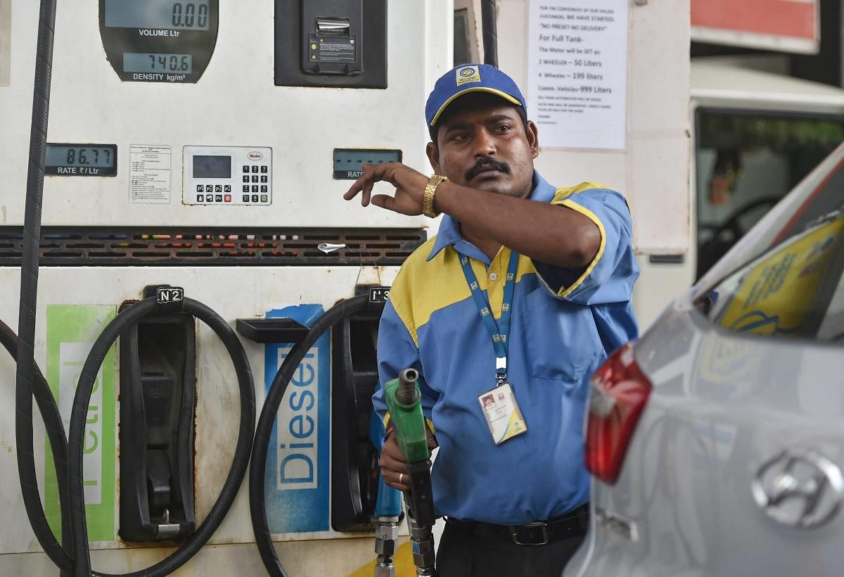 COSTLY FILL: An employee points towards the revised prices of petrol and diesel at a fuel station in Mumbai. PTI