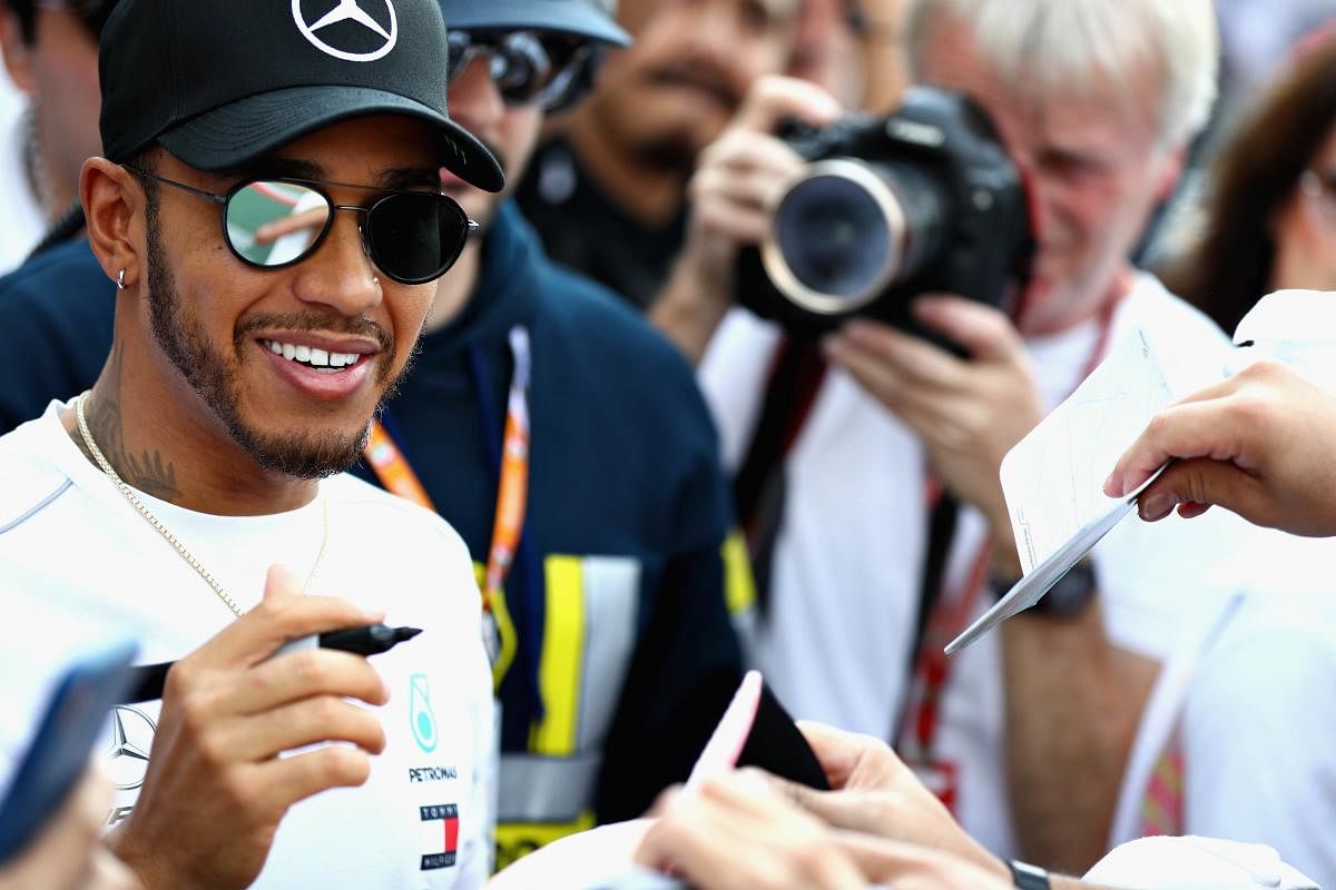 STAR ATTRACTION: Mercedes driver Lewis Hamilton signs autographs for fans in the pitlane ahead of the Mexico Grand Prix. AFP