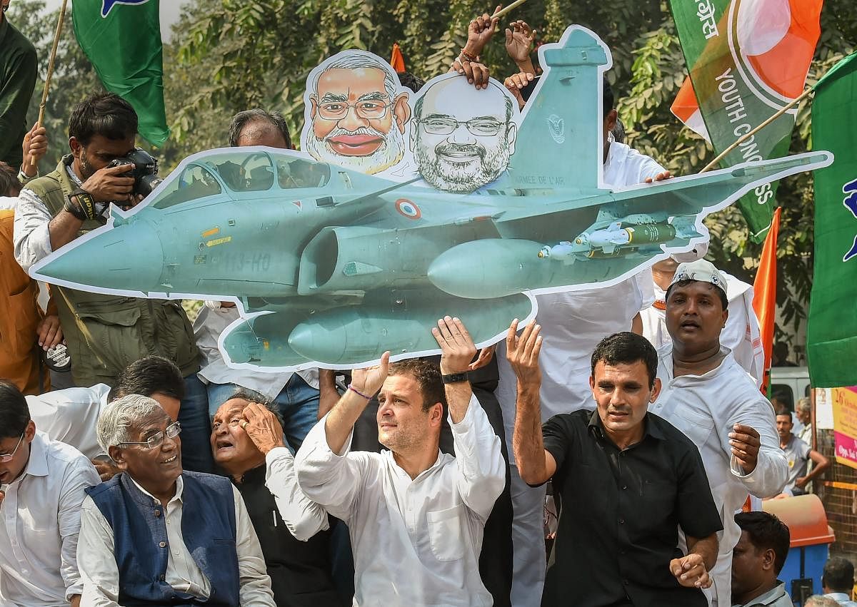 Congress president Rahul Gandhi holds a cutout of a fighter aircraft during a protest demanding the reinstatement of CBI Director Alok Verma outside the CBI headquarters, in New Delhi, on Friday. PTI
