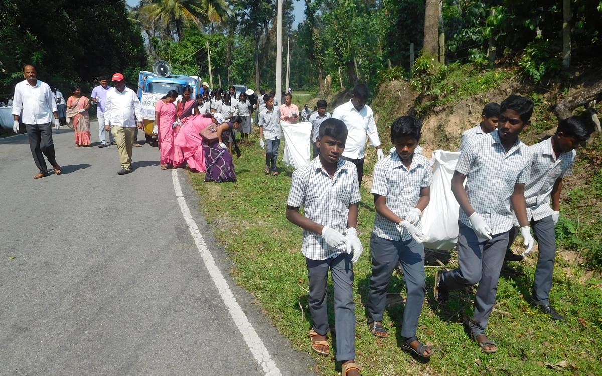 Schoolchildren, Asha workers and other volunteers take part in cleanliness drive at Koove Gram Panchayat in Mudigere.