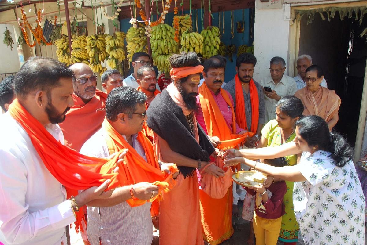 Dattamaladharis collect alms from households in Chikkamagaluru on Saturday.