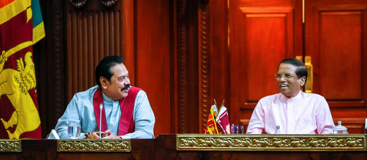 Sri Lanka's newly appointed Prime Minister Mahinda Rajapaksa (L) smiles next to President Maithripala Sirisena during their party members' meeting in Colombo, Sri Lanka October 27, 2018. Sri Lanka's President's Office/Handout via REUTERS