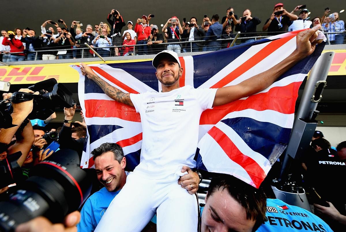 ON TOP OF THE WORLD: Mercedes driver Lewis Hamilton celebrates with team-mates after winning his fifth world championship crown in Mexico City on Sunday. AFP