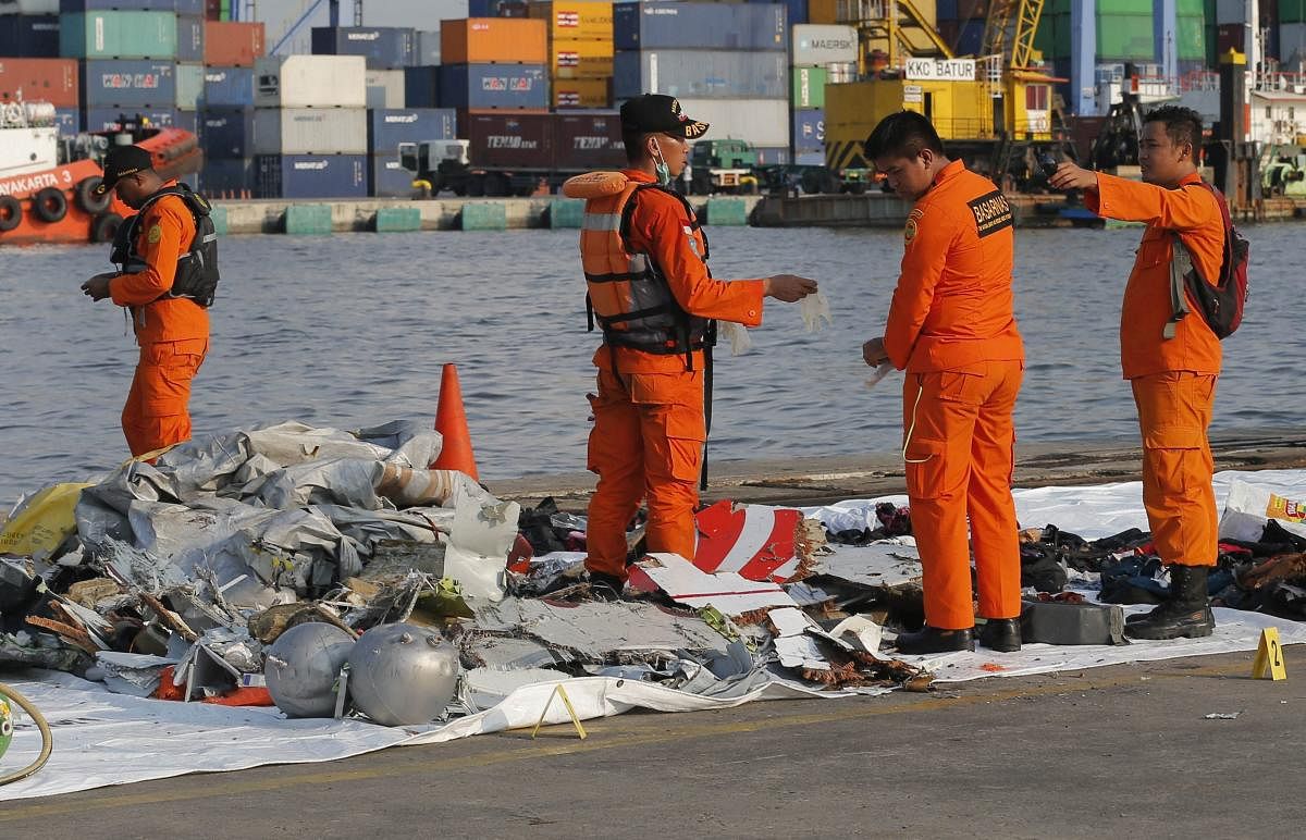 Members of Indonesian Search and Rescue Agency (BASARNAS) inspect debris recovered from near the waters where a Lion Air passenger jet is suspected to crash, at Tanjung Priok Port in Jakarta, Indonesia. (AP/PTI File Photo)