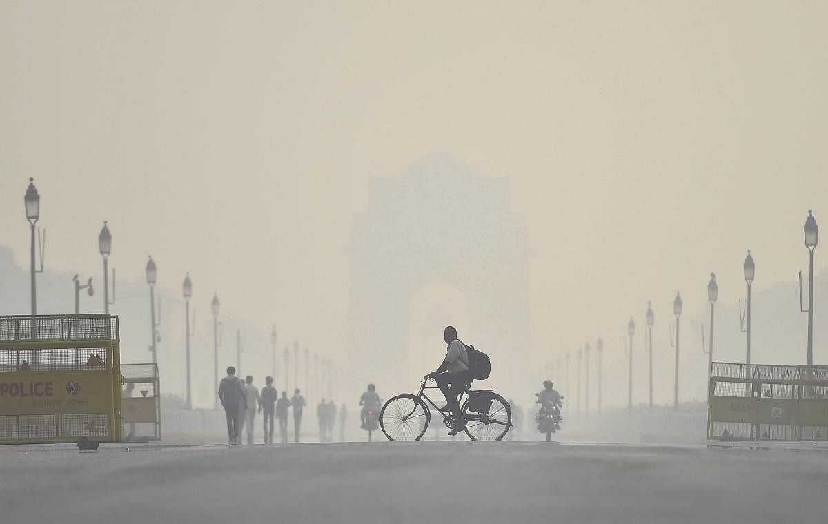 A cyclist rides through the heavy haze at Rajpath in New Delhi. About 44 joint teams from various agencies will be deployed to check air pollution in the national capital as the air quality in the city nosedived to 'severe' category. (PTI Photo)