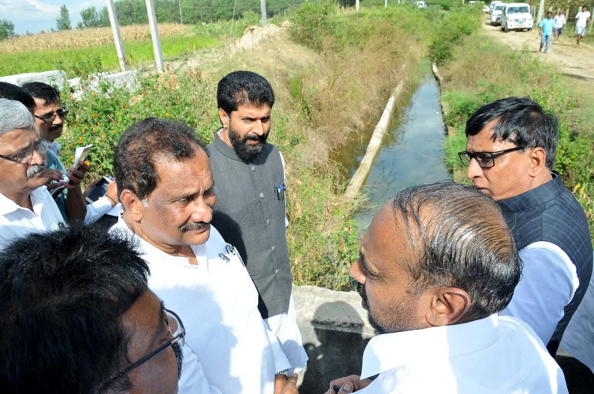 MLC S L Dharme Gowda explains the condition of Karagada canal to District In-charge Minister K J George.