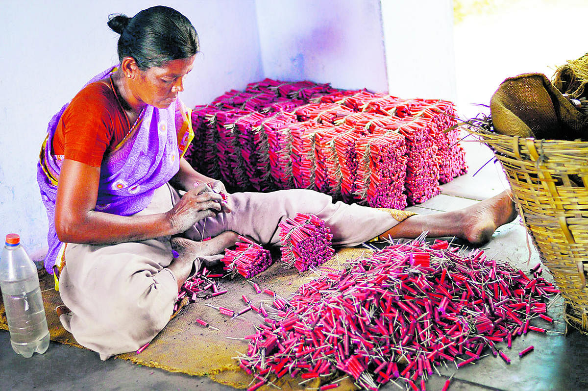 Sivakasi: A woman employee making crackers at a factory in Sivakasi district in Tamil Nadu. The firecrackers business may be hit by crores due the ban on its sale in Delhi National Capital Region till October 31. PTI Photo(PTI10_10_2017_000181B)PTI10_10_