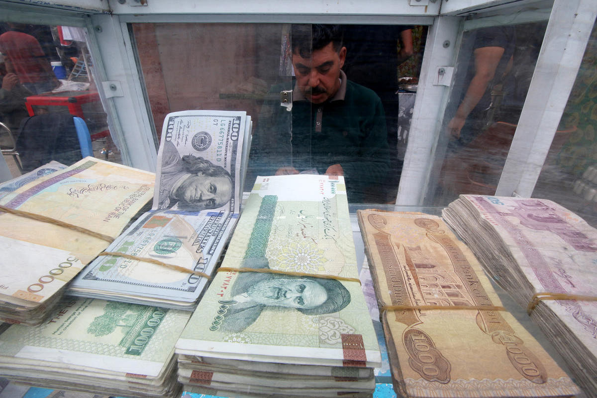 A man counts Iranian rials at a currency exchange shop, before the start of the U.S. sanctions on Tehran in Basra. Reuters photo