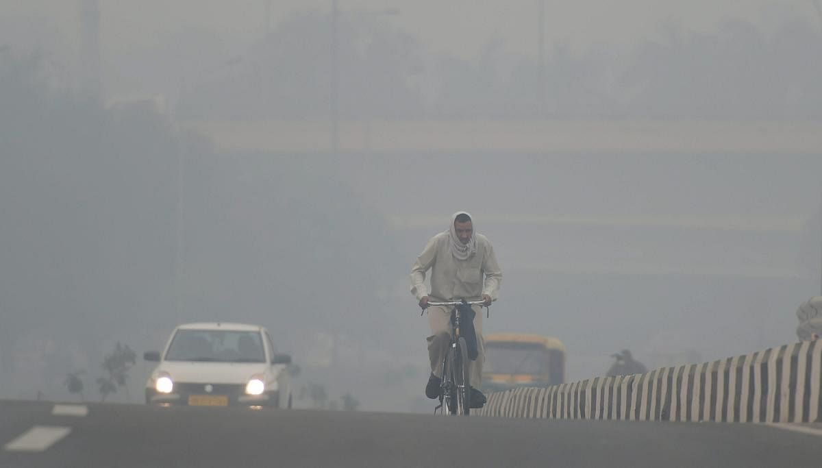 A cyclist rides through heavy haze, in New Delhi. PTI photo