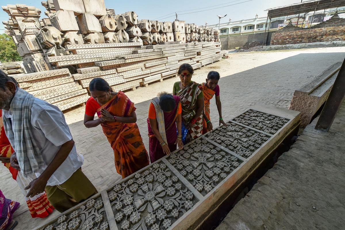 Visitors look at chiseled slabs of stone for a Ram temple at Kar Sevak Puram workshop in Ayodhya on Monda. PTI file photo