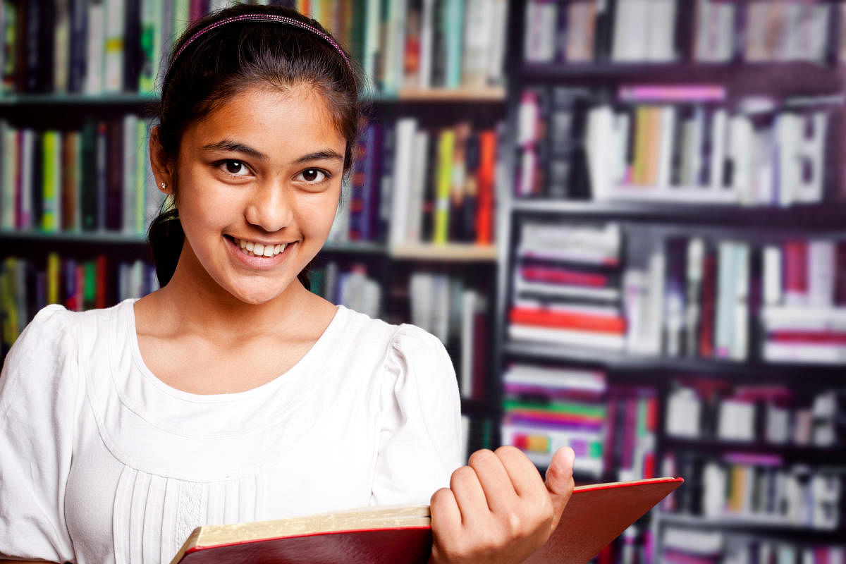 Indian Teenager Girl studying in a Library with BookshelfEducation, Student